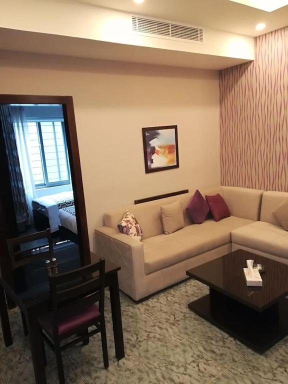 Weibdeh View Apartment في عمّان: غرفة معيشة مع أريكة وطاولة