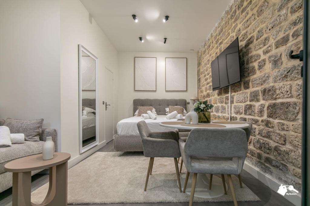 une chambre avec un lit et un mur de briques dans l'établissement MBA - Splendide Appartement - Proche Nation, à Paris