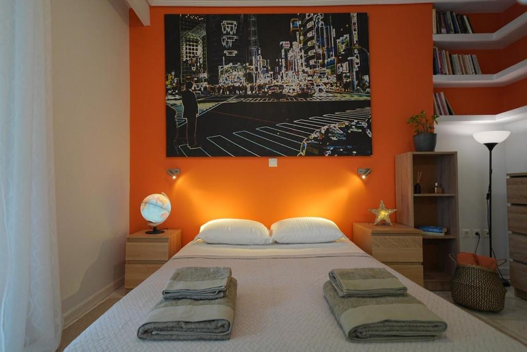 a bedroom with a bed with an orange wall at Summer Vacation Home in Vouliagmeni for 4 in Athens