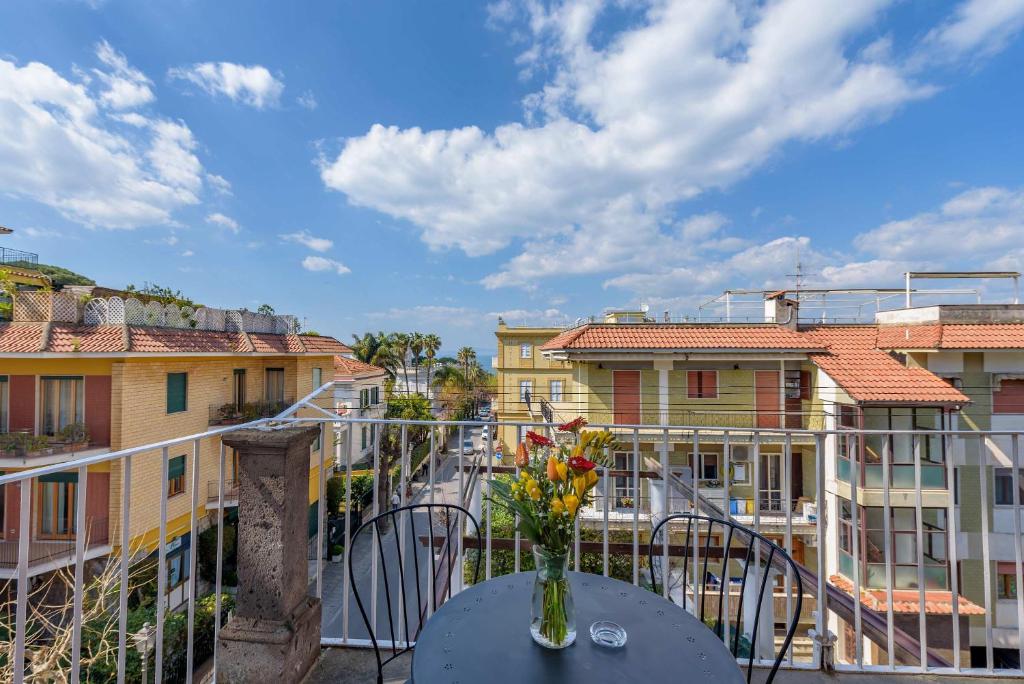 eine Vase mit Blumen auf einem Tisch auf einem Balkon in der Unterkunft Maramia Luxury Apartment in Sant'Agnello