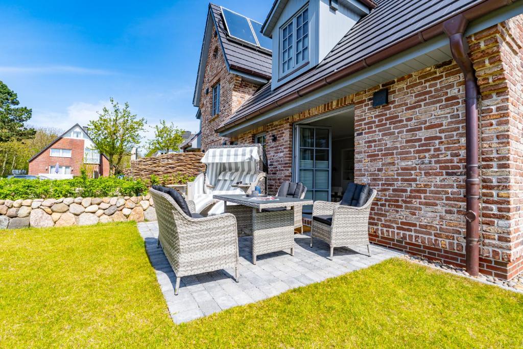 a patio with a table and chairs on a lawn at Haus Marit in Westerland