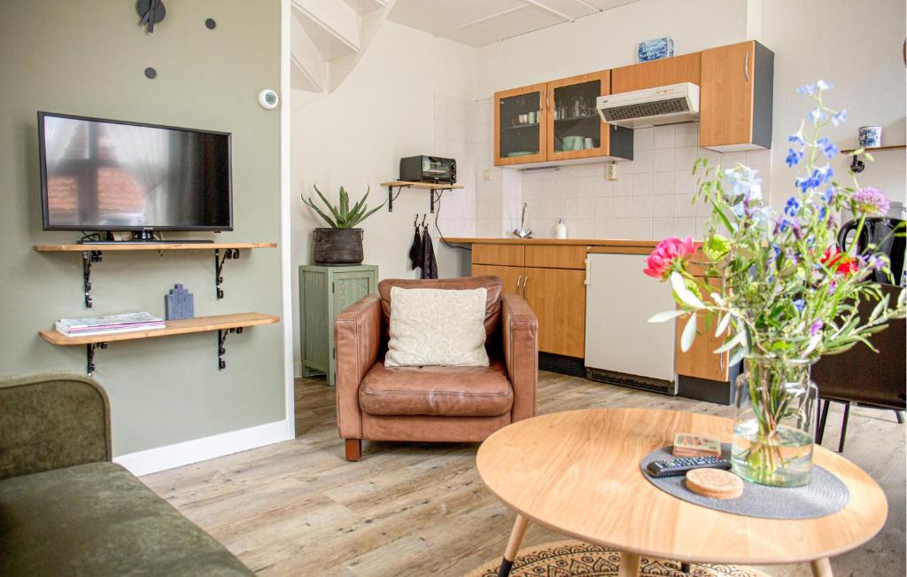 a living room with a couch and a table with flowers at 1 Bedroom Lovely Home In Blokzijl in Blokzijl