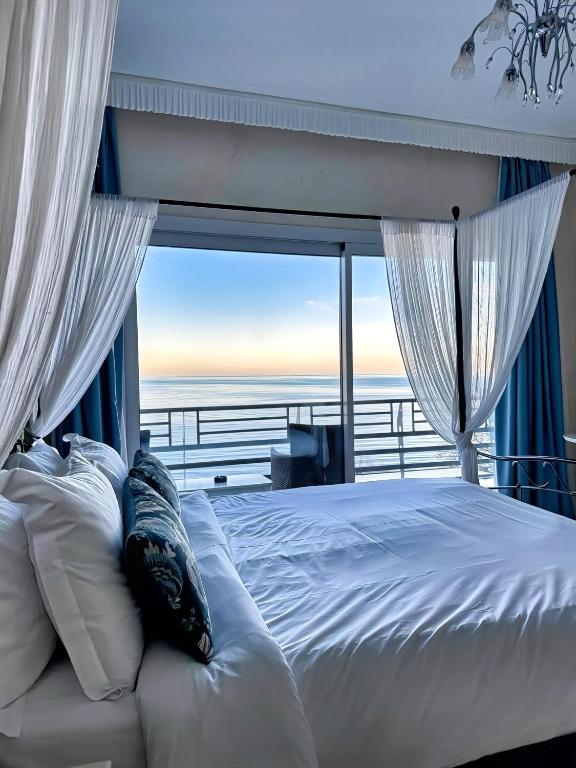 sypialnia z łóżkiem i widokiem na ocean w obiekcie Panorama Suites & Spa - Adults Only w mieście Stomio