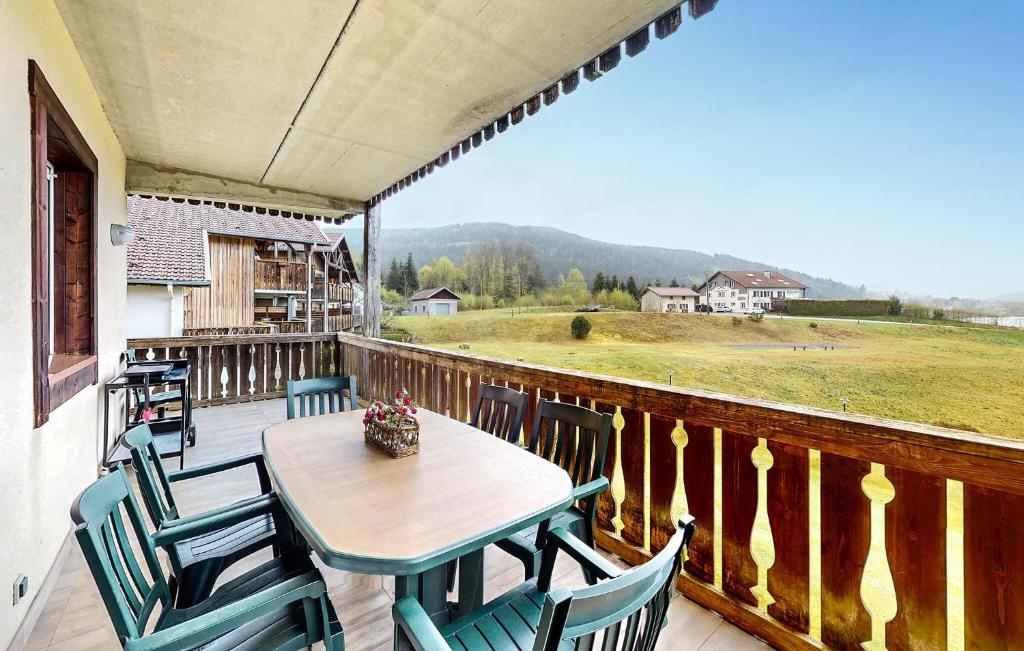 d'une table et de chaises en bois sur un balcon avec vue. dans l'établissement Gorgeous Apartment In Gérardmer, à Gérardmer