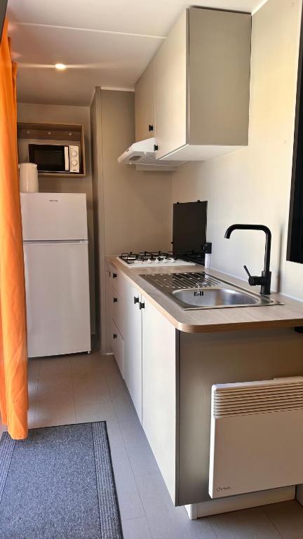 a small kitchen with a sink and a stove at Camping Villa Park Zambujeira do Mar in Zambujeira do Mar