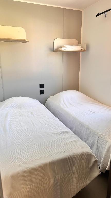 two beds sitting next to each other in a room at Camping Villa Park Zambujeira do Mar in Zambujeira do Mar