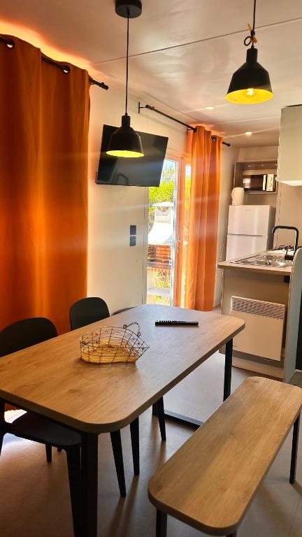 a kitchen with a wooden table and two benches at Camping Villa Park Zambujeira do Mar in Zambujeira do Mar