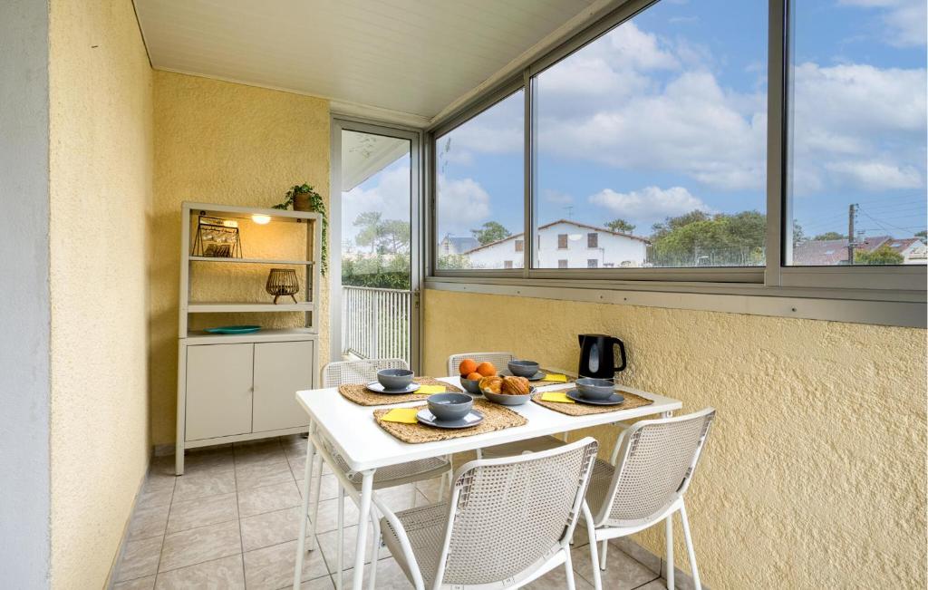 une salle à manger avec une table, des chaises et des fenêtres dans l'établissement Awesome Apartment In Saint-Georges-De-Didon, à Saint-Georges-de-Didonne
