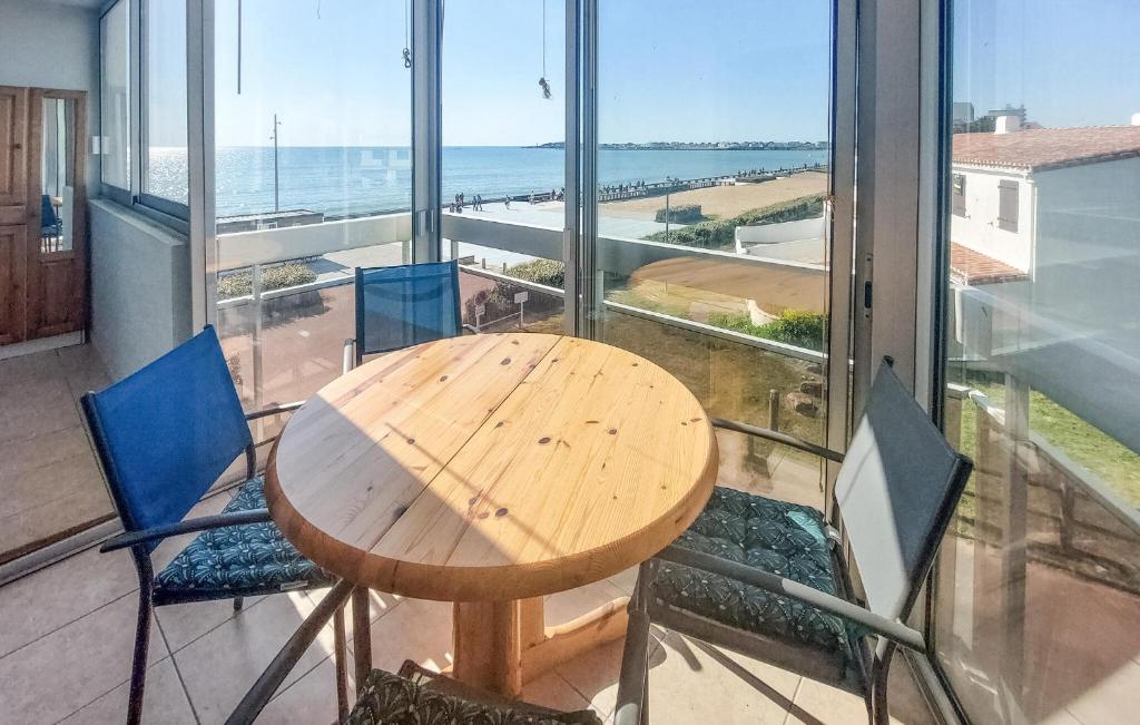 a table and chairs in a room with a view of the ocean at Cozy Apartment In Saint Gilles Croix De in Le Sablais