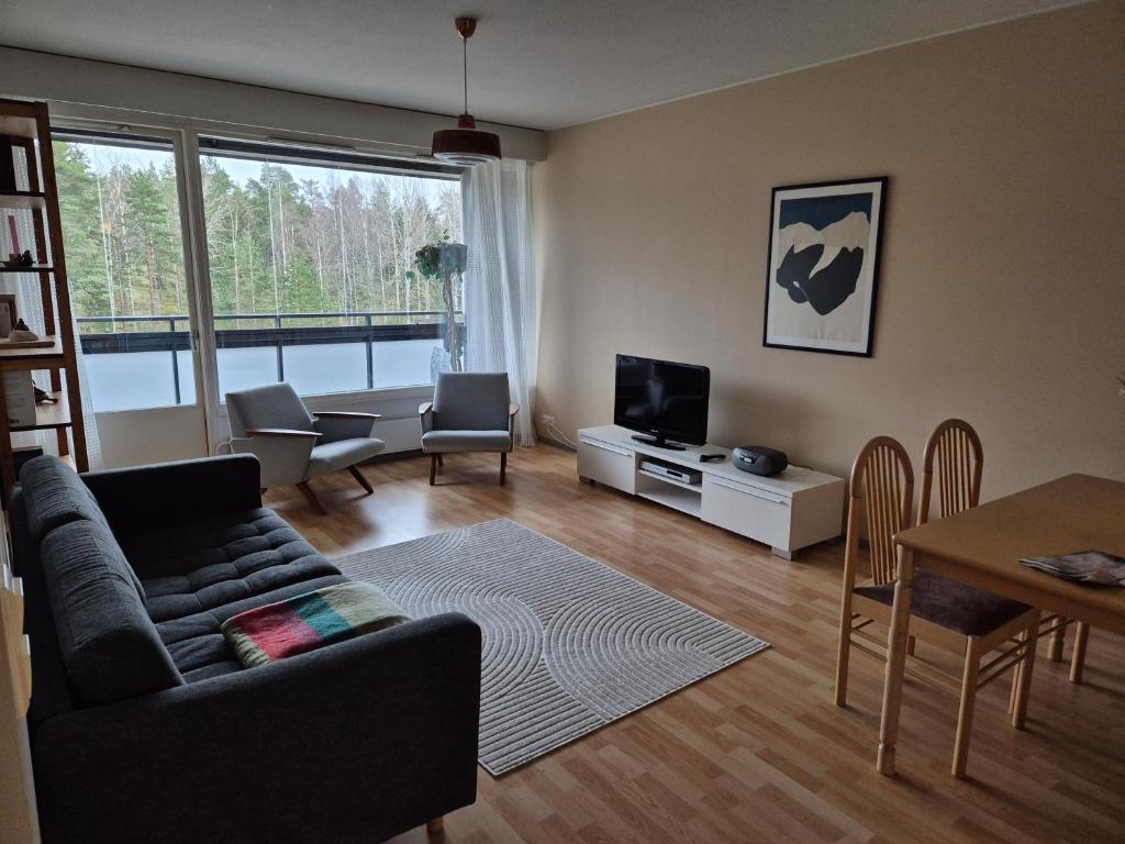 Una sala de estar con un sofá, un televisor y una mesa. en Kirkkonummi Rock, en Pikkala