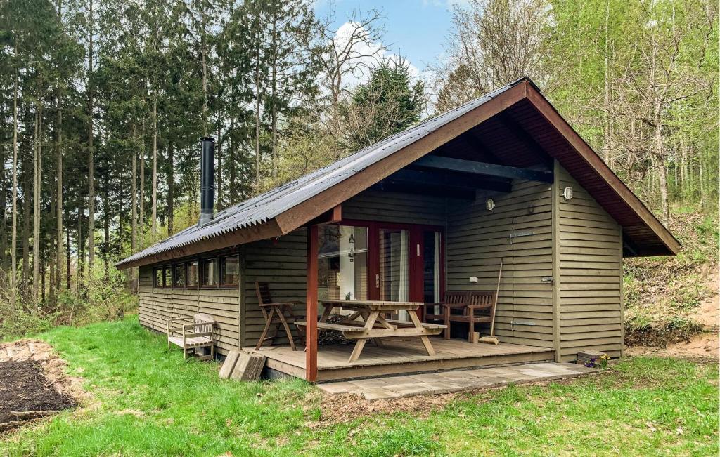 a wooden cabin with a table and chairs in a forest at 2 Bedroom Gorgeous Home In Ebeltoft in Ebeltoft