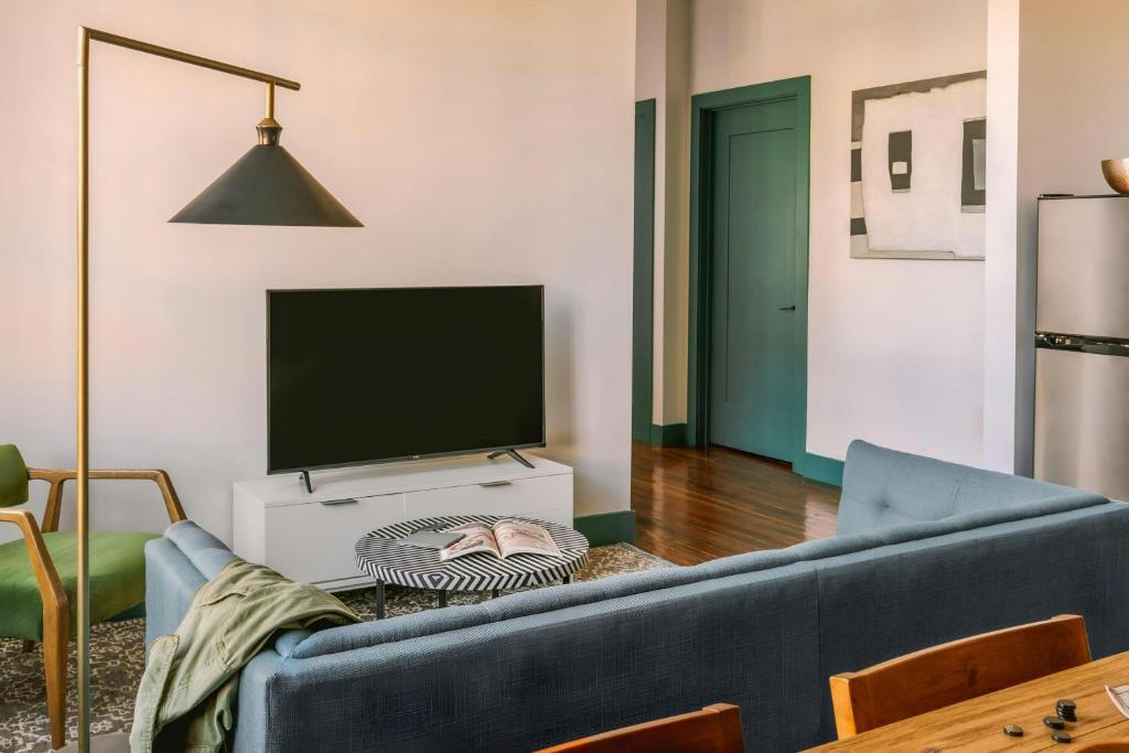 ein Wohnzimmer mit einem blauen Sofa und einem Fernseher in der Unterkunft Sonder by Marriott Bonvoy The Schaeffer Apartments French Quarter in New Orleans