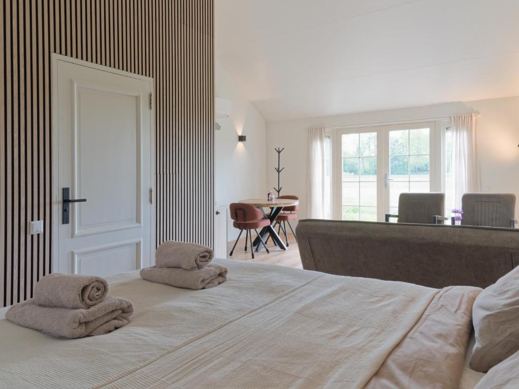 a bedroom with a large bed with towels on it at Hof van Eese - Rust, Ruimte en Landelijk Genieten in Eesveen