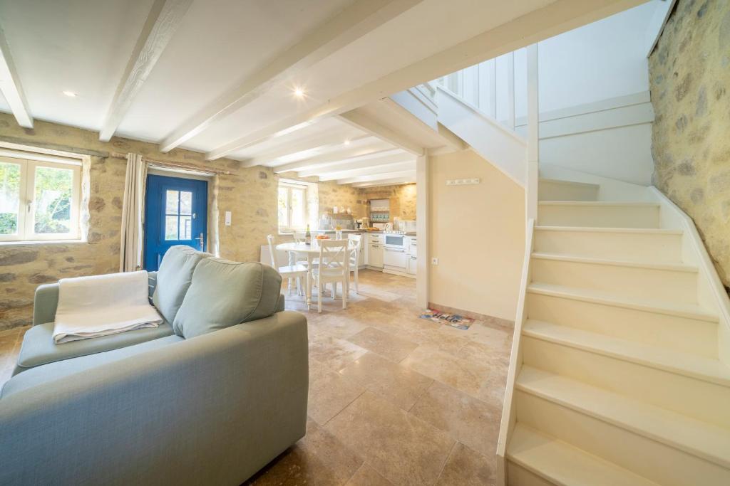 un salon avec un escalier et un canapé dans l'établissement chaumière typique bretonne, à Carnac