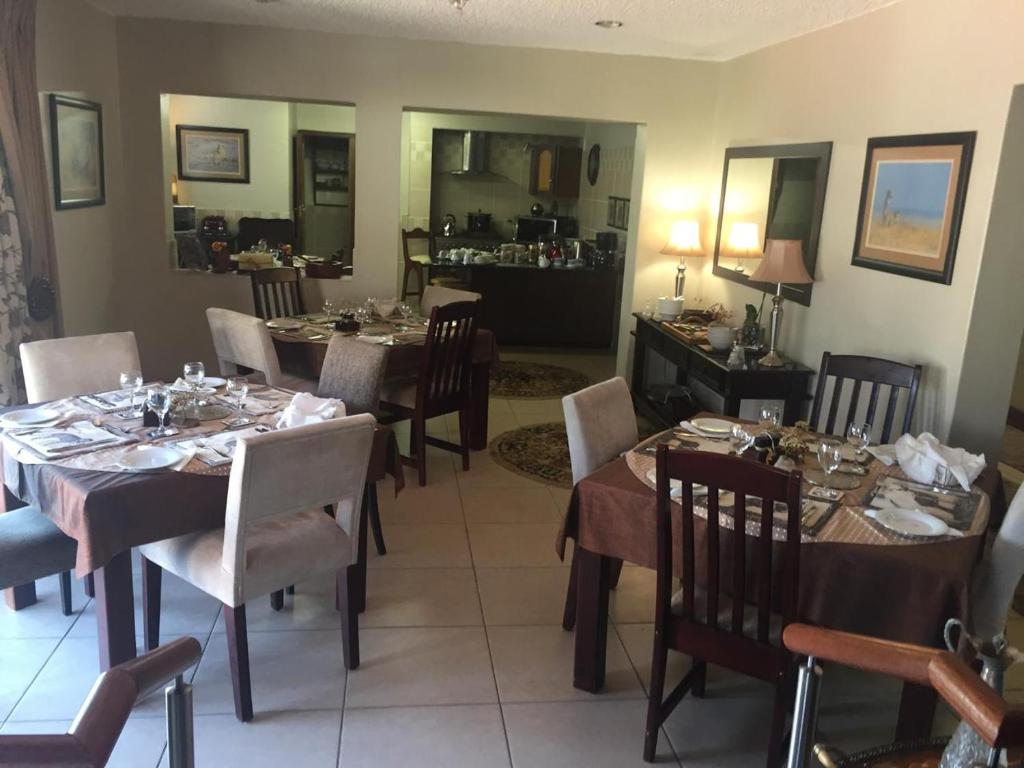 a dining room with several tables and chairs at 125 on Van Buuren Road Guest House in Johannesburg
