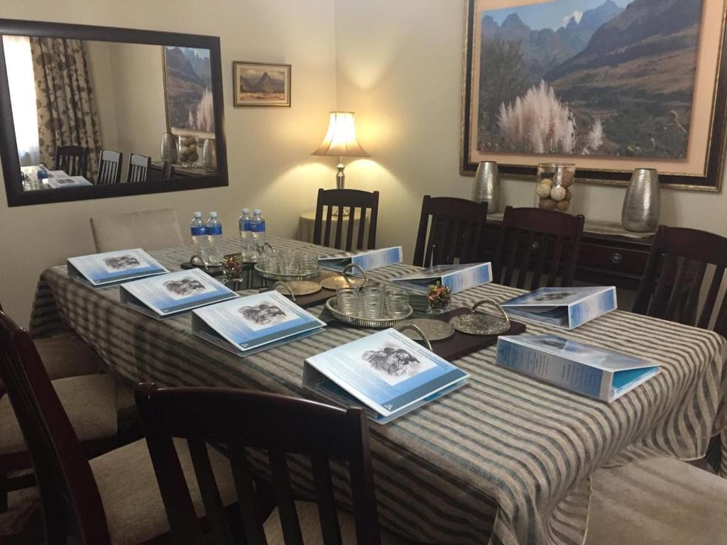 a dining room table with a striped table cloth and chairs at 125 on Van Buuren Road Guest House in Johannesburg