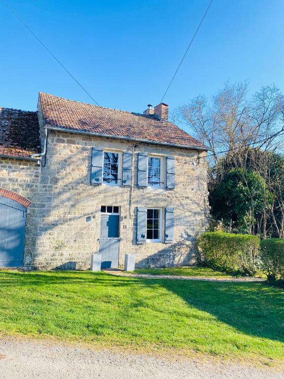 une ancienne maison en pierre sur une pelouse dans l'établissement Gîte La Vie Verte, à Saint-Domet