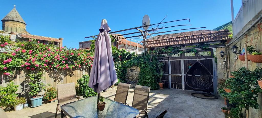 VILLA SABA WITH TWO BEDROOMS- სასტუმრო საბა في متسختا: وجود مظلة للجلوس على طاولة في ساحة الفناء