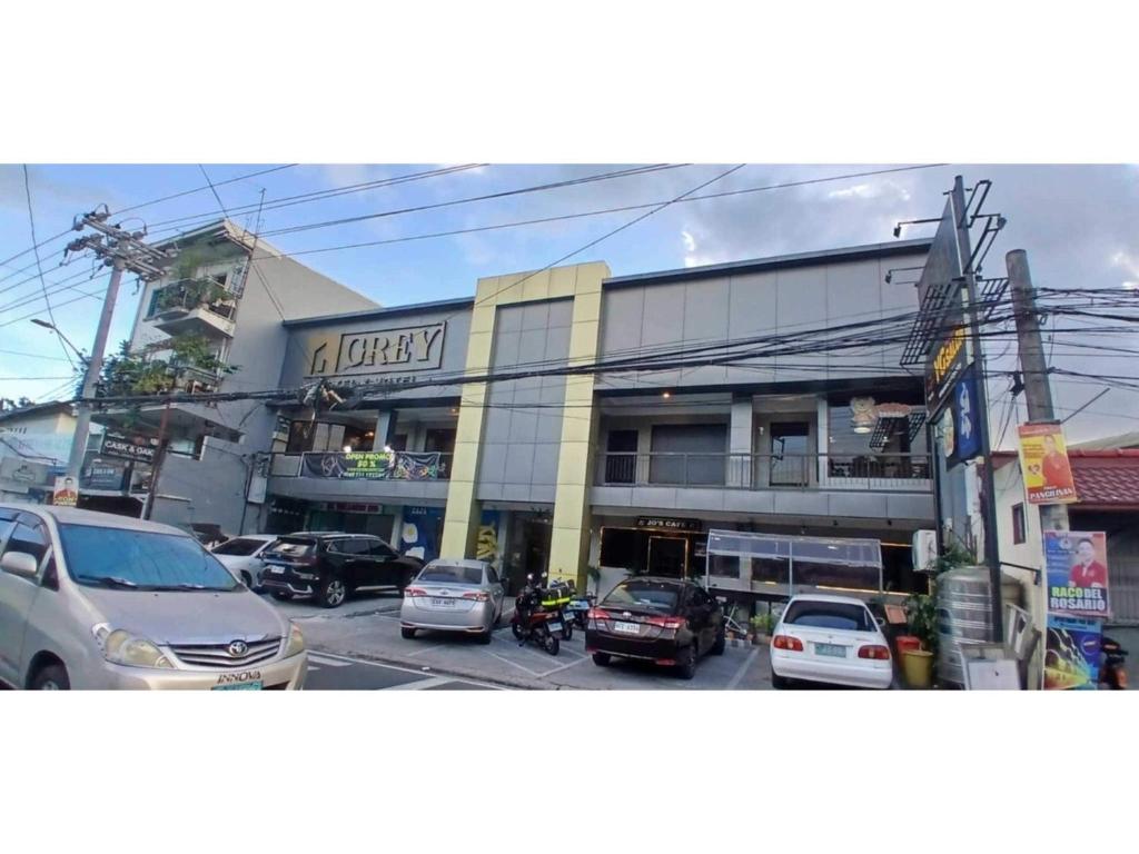 a building with cars parked in front of it at Townhouse Oak Grey Hotel Near Clark International Airport in Pampang