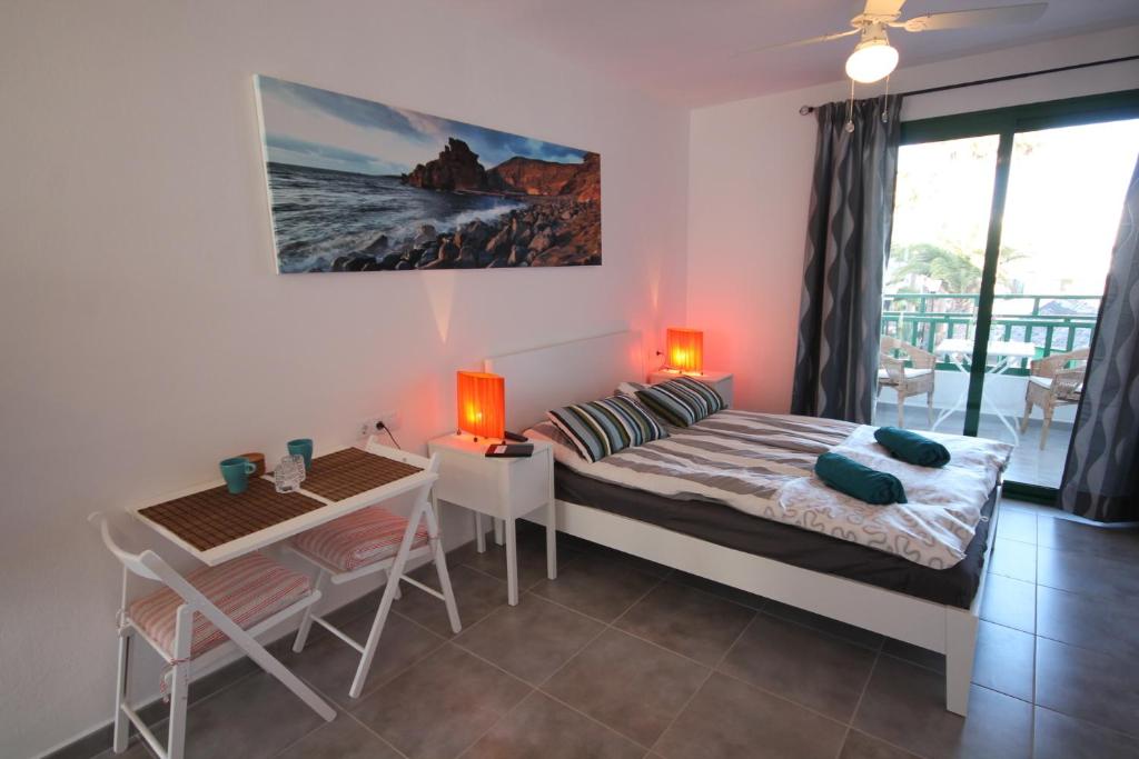 1 dormitorio con 1 cama, mesa y sillas en Casa Linda, en Costa Teguise