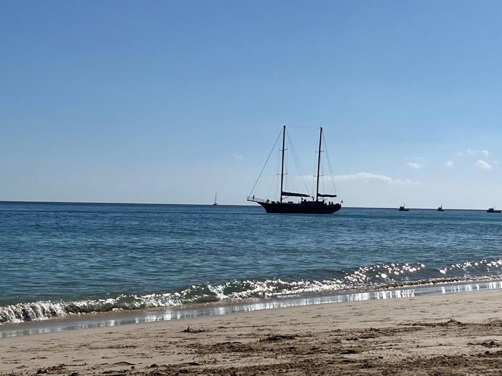 a boat floating in the ocean next to a beach at Casa Monte y Mar in Morro del Jable