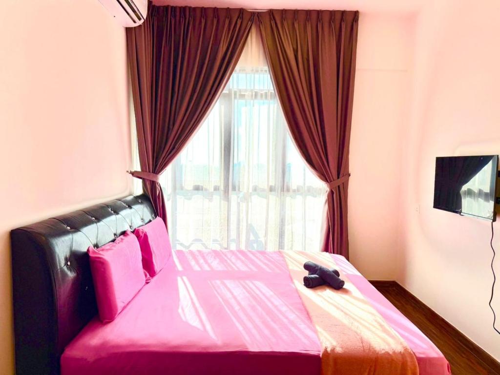 a bedroom with a pink bed with a window at K avenue Studio by TZhomestay in Donggongon