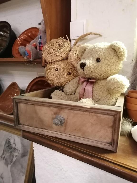 deux ours en peluche assis dans une boîte en bois dans l'établissement La Colombe, à Beblenheim