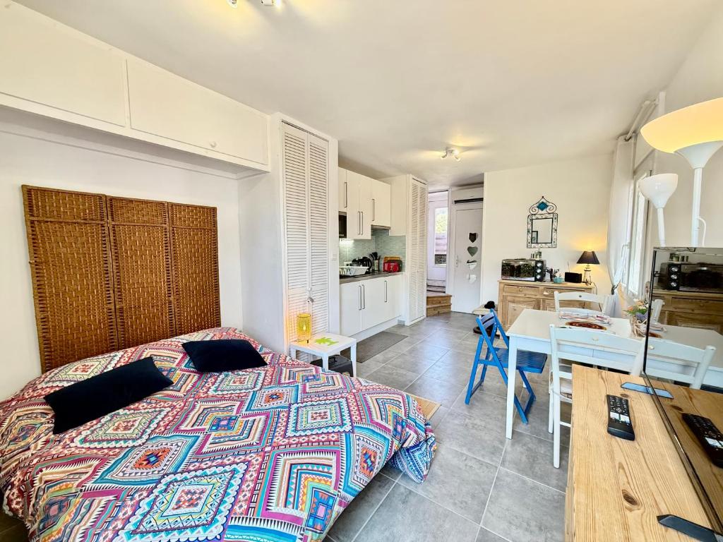 une chambre avec un grand lit et une cuisine dans l'établissement Studio Moderne - Terrasse - Parking Privé, à Carqueiranne