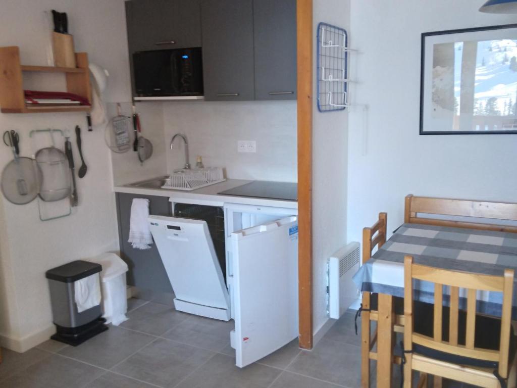 une petite cuisine avec un évier et une table dans l'établissement Appartement cosy avec balcon · Proche des pistes · Belle Plagne - FR-1-181-2220, à La Plagne Tarentaise