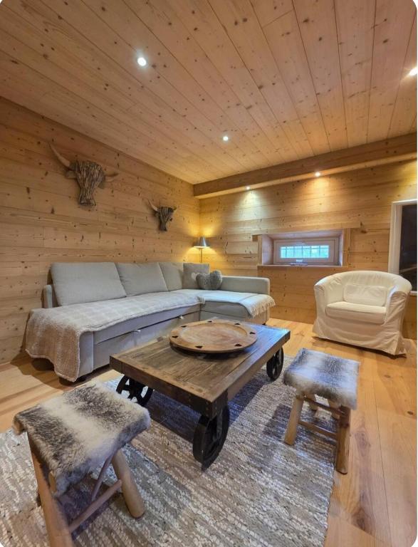 a living room with a bed and a coffee table at Appartement au rez de jardin d'une villa Mexicaine in Barcelonnette