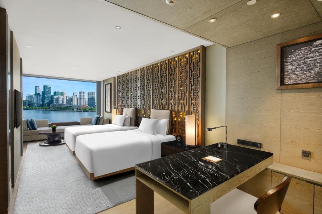 上海上海外滩悦榕庄 - 顶楼露台Tales餐厅酒吧纵览浦江美景的一间配有白色床和书桌的酒店房间