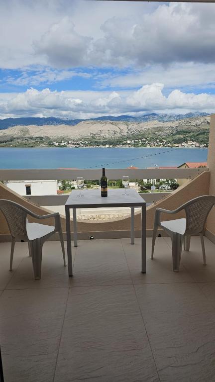 a bottle of wine sitting on a table on a balcony at Sun Anna Apartments in Pag