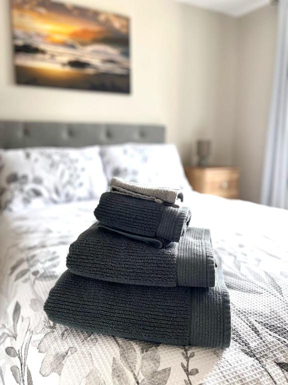 three towels stacked on top of a bed at Tigh Fitz Apartments - Inis Mór, Aran Island in Inis Mor