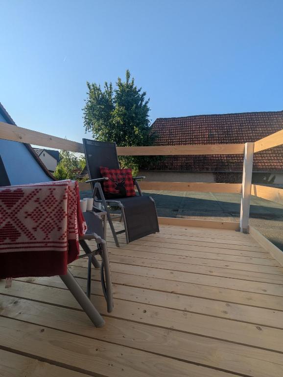 a pair of chairs sitting on a wooden deck at Ferienwohnung Rheinwald in Hartheim