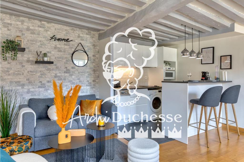 un salon avec un canapé bleu et une cuisine au défi dans l'établissement Bienvenue au Solenne votre pied-à-terre de charme au cœur de Rouen, à Rouen