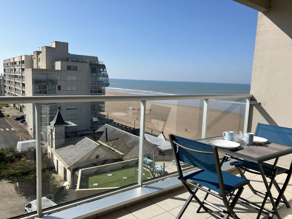 une chaise bleue assise sur un balcon avec vue sur l'océan dans l'établissement GREEMENT SAINT GILLES CROIX DE VIE, à Saint-Gilles-Croix-de-Vie