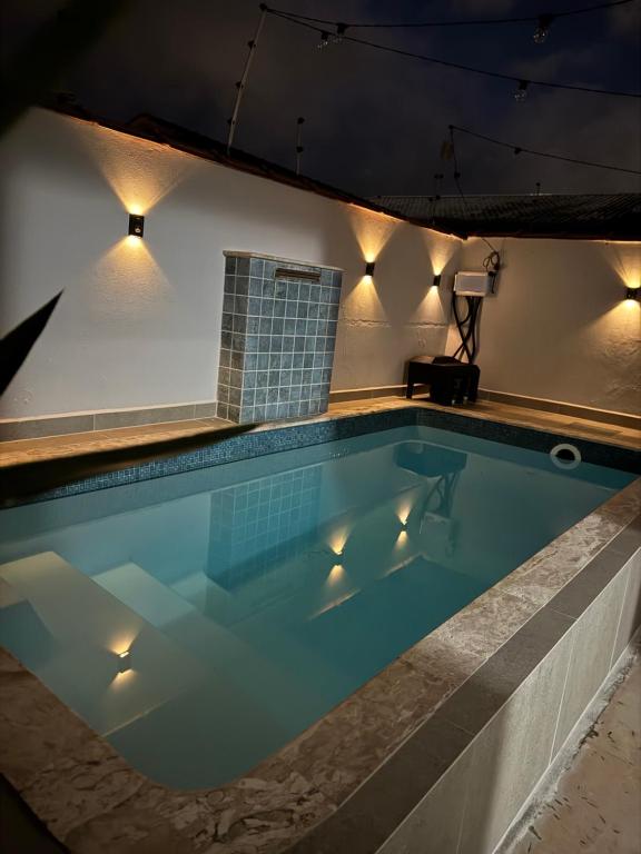 a swimming pool at night with lights on it at Casa Carvalho in Peruíbe