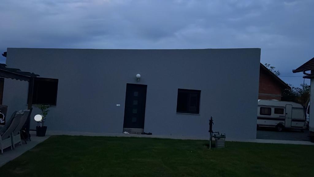 a white house with a green lawn in front of it at Ferienhaus Rovine in Ivišovo Greblje