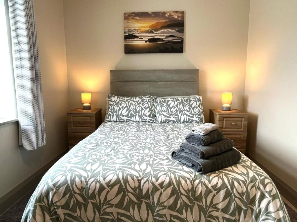 a bedroom with a bed with pillows and two lamps at Tigh Fitz Apartments - Inis Mór, Aran Island in Inis Mor