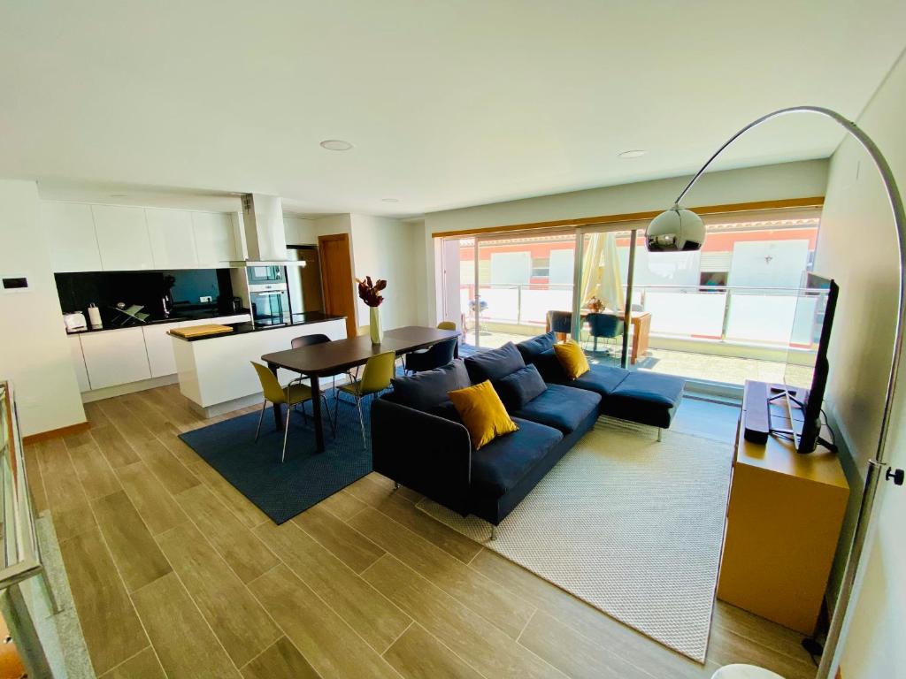 a living room with a blue couch and a table at Apartamento Duplex - Beach Apart in Vila Praia de Âncora