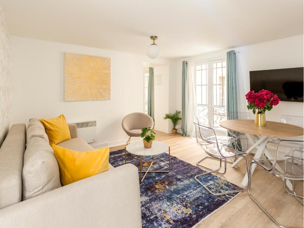 un salon avec un canapé et une table dans l'établissement Merveil - Family Suite - Louvre - Rivoli, à Paris