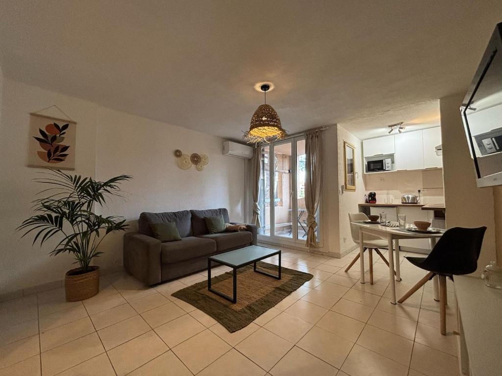 un salon avec un canapé et une table dans l'établissement Studio with pool and tennis, à Fréjus