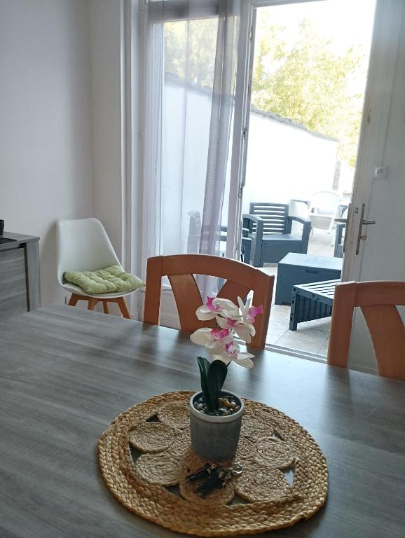 un vase de fleurs sur une table dans le salon dans l'établissement Maisonlille, à Lille