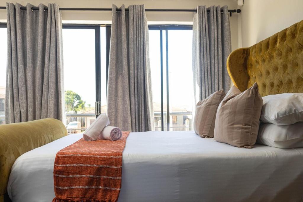 a bedroom with a bed with a large window at Bluewater Bay Escape in Gqeberha