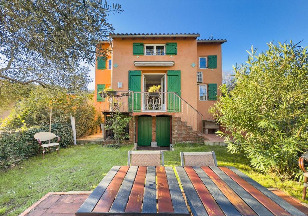 une maison avec une terrasse en bois devant elle dans l'établissement Au bord de la rivière-Classé 2 étoiles, à Collobrières