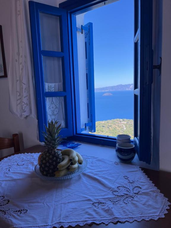 a pineapple on a table in front of a window at Emporios Traditional Sea View House in Emporeiós