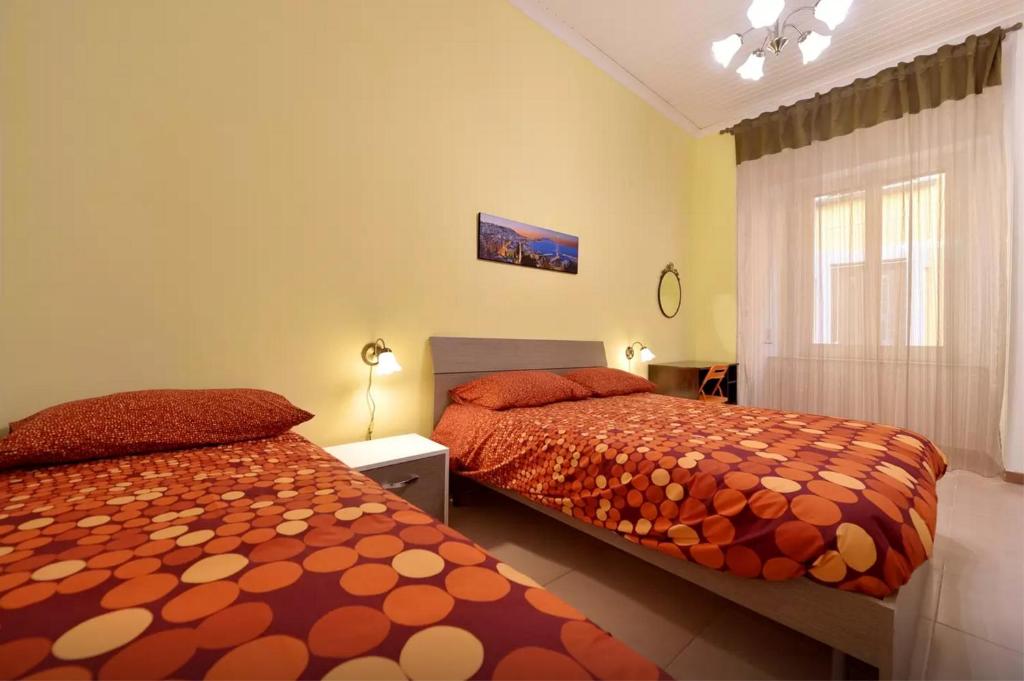 ナポリにあるTrimarchi Houseのベッドルーム1室(ベッド2台、窓付)