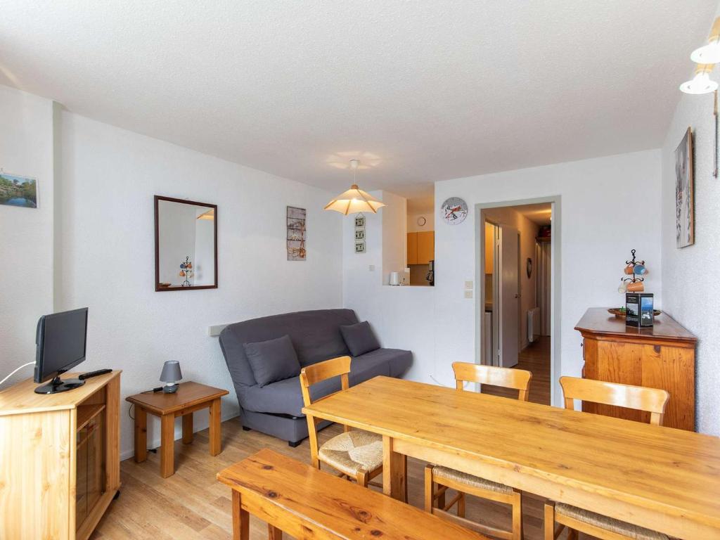 un salon avec un canapé bleu et une table dans l'établissement Studio 5 pers. proche pistes, balcon, casier à skis, non-fumeur - FR-1-404-81, à La Mongie