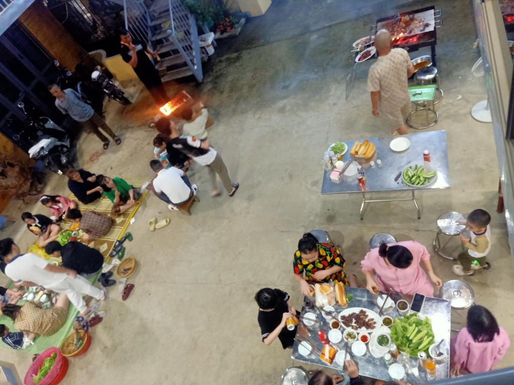 a group of people sitting around a table with food at Viena Homestay in Bắc Hà