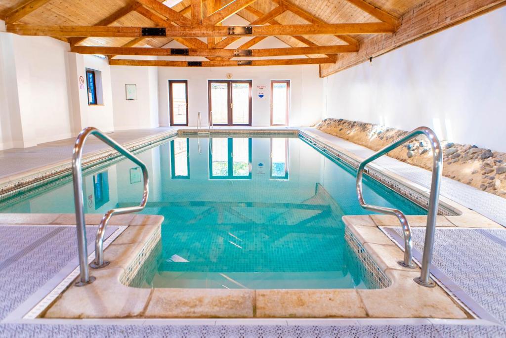 a indoor swimming pool with stairs in a building at Church Farm Country Cottages in Freshford